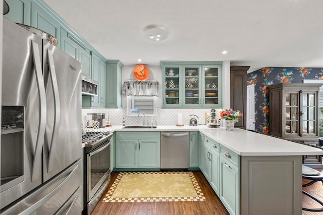 4088 Sweet Shadow Ave, Columbus, OH 43230 - kitchen with appliances with stainless steel finishes, a sink, a peninsula, a breakfast bar, and green cabinetry