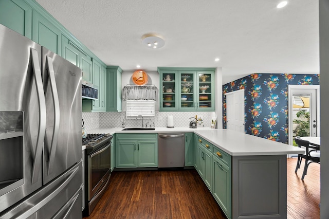 4088 Sweet Shadow Ave, Columbus, OH 43230 - kitchen featuring stainless steel appliances, green cabinetry, a peninsula, wallpapered walls, and dark wood-type flooring