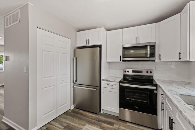 4778 Hafey Ave, Columbus, OH 43228 - kitchen featuring stainless steel appliances, dark wood-style floors, white cabinetry, and light stone counters