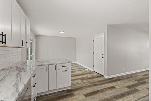 4778 Hafey Ave, Columbus, OH 43228 - kitchen with a peninsula, wood finished floors, white cabinets, light stone countertops, and decorative backsplash