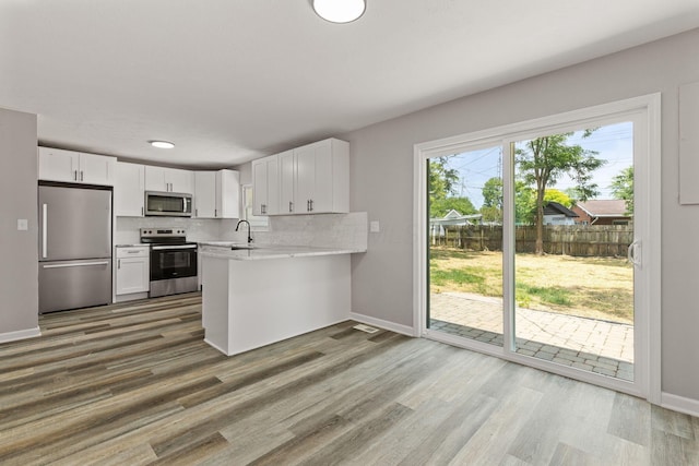 4778 Hafey Ave, Columbus, OH 43228 - kitchen featuring appliances with stainless steel finishes, light countertops, white cabinets, a peninsula, and tasteful backsplash