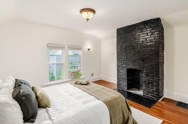 1089 Perry St, Columbus, OH 43201 - bedroom with lofted ceiling, wood finished floors, baseboards, a brick fireplace, and cooling unit