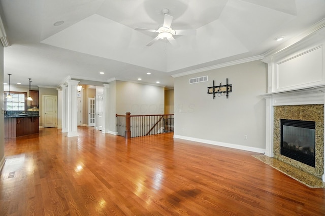 4993 Denbigh Ct, Columbus, OH 43220 - unfurnished living room featuring a fireplace, a ceiling fan, crown molding, a raised ceiling, and light wood-type flooring