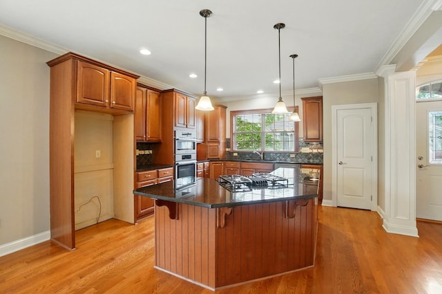4993 Denbigh Ct, Columbus, OH 43220 - kitchen with gas cooktop, brown cabinetry, a kitchen breakfast bar, dark countertops, and crown molding