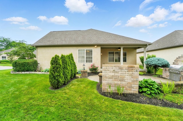 4993 Denbigh Ct, Columbus, OH 43220 - view of front facade with a front yard, a ceiling fan, stucco siding, and a shingled roof