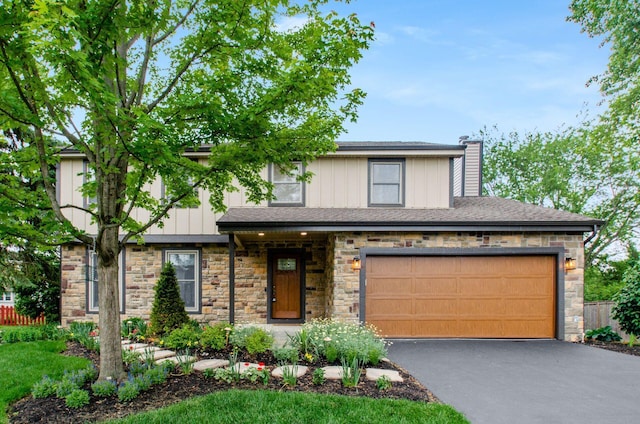 1672 Flat Rock Ct, Columbus, OH 43235 - view of front of house with driveway, stone siding, a chimney, and board and batten siding