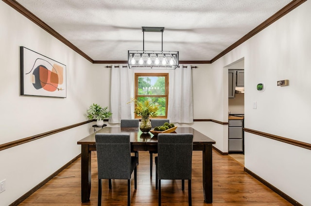 1672 Flat Rock Ct, Columbus, OH 43235 - dining area featuring light wood-style floors, baseboards, crown molding, a textured ceiling, and a chandelier