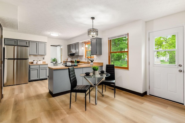 1672 Flat Rock Ct, Columbus, OH 43235 - kitchen featuring freestanding refrigerator, gray cabinets, light wood finished floors, a peninsula, and a textured ceiling