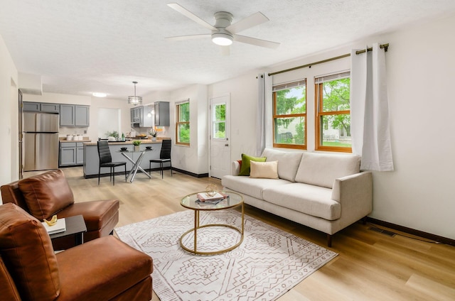 1672 Flat Rock Ct, Columbus, OH 43235 - living room featuring light wood-style flooring, baseboards, ceiling fan, and a textured ceiling