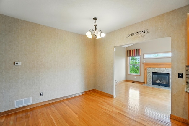 790 Salinger Dr, Lithopolis, OH 43136 - unfurnished living room with light wood finished floors, a chandelier, baseboards, and a high end fireplace