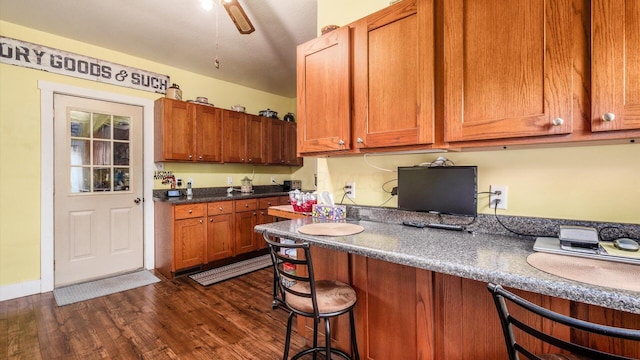 12151 State Route 93 N, Logan, OH 43138 - kitchen with a breakfast bar area, dark wood-type flooring, dark countertops, and brown cabinetry