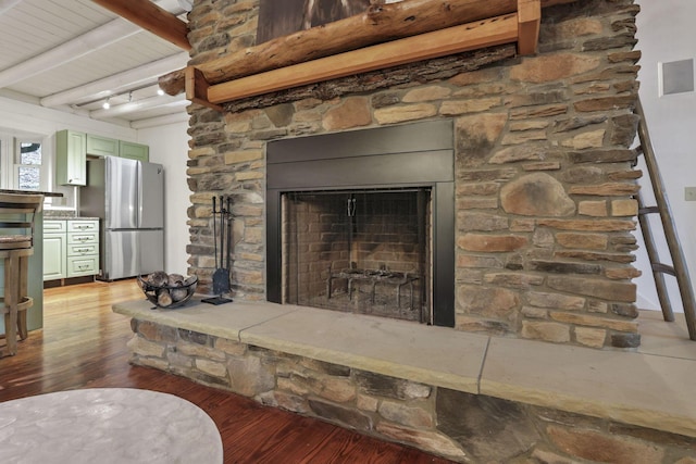 510 Natchez Ln, Sugar Grove, OH 43155 - detailed view of freestanding refrigerator, wood finished floors, beamed ceiling, and a fireplace