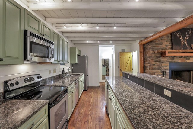 510 Natchez Ln, Sugar Grove, OH 43155 - kitchen with green cabinetry, appliances with stainless steel finishes, wood-type flooring, dark stone counters, and a fireplace with raised hearth