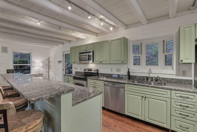 510 Natchez Ln, Sugar Grove, OH 43155 - kitchen featuring appliances with stainless steel finishes, green cabinetry, a sink, a kitchen bar, and light wood finished floors