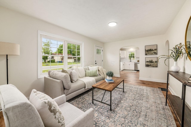 3232 Williams Rd, Columbus, OH 43207 - living room featuring arched walkways, wood finished floors, and baseboards