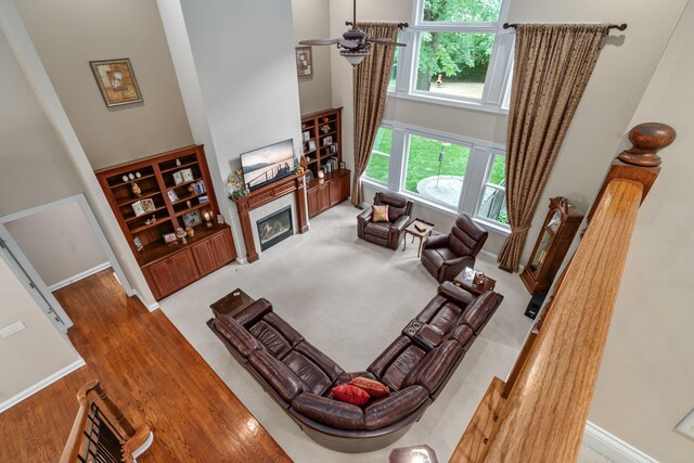 7607 Stone Ridge Dr, Springboro, OH 45066 - living area featuring a towering ceiling, a glass covered fireplace, baseboards, and wood finished floors