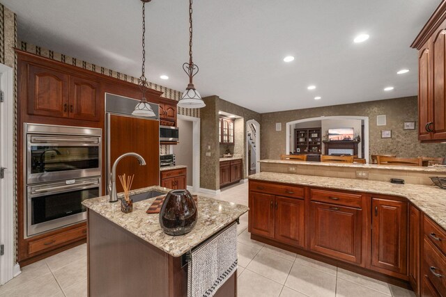 7607 Stone Ridge Dr, Springboro, OH 45066 - kitchen with appliances with stainless steel finishes, a sink, light tile patterned floors, arched walkways, and recessed lighting