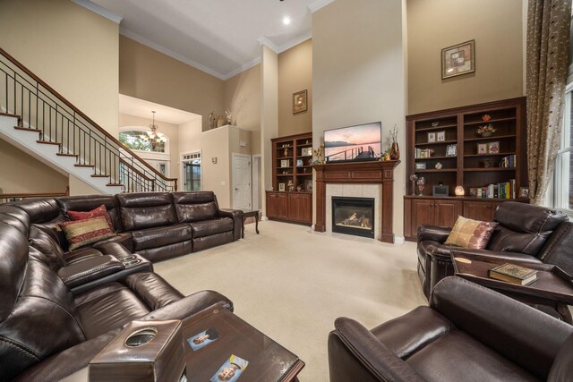 7607 Stone Ridge Dr, Springboro, OH 45066 - living room with a towering ceiling, crown molding, light colored carpet, stairs, and a chandelier