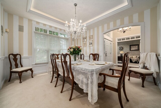 7607 Stone Ridge Dr, Springboro, OH 45066 - dining space with a chandelier, wallpapered walls, light colored carpet, a raised ceiling, and a wainscoted wall