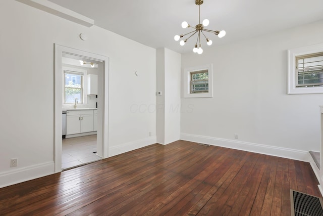 399 E Woodrow Ave, Columbus, OH 43207 - spare room with a chandelier, healthy amount of natural light, and dark wood-style flooring