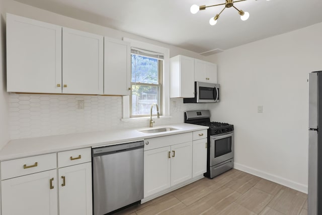 399 E Woodrow Ave, Columbus, OH 43207 - kitchen featuring stainless steel appliances, backsplash, white cabinets, and light countertops