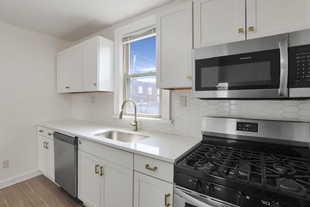 399 E Woodrow Ave, Columbus, OH 43207 - kitchen featuring stainless steel appliances, tasteful backsplash, light countertops, and white cabinets