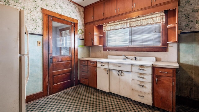 8045 Old Town Rd, Roseville, OH 43777 - kitchen with freestanding refrigerator, light countertops, dark colored carpet, brown cabinets, and open shelves