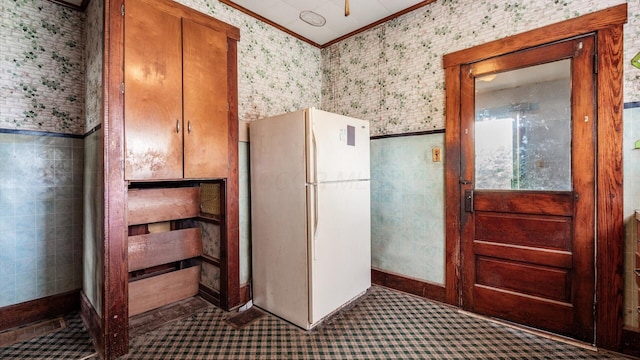 8045 Old Town Rd, Roseville, OH 43777 - kitchen featuring freestanding refrigerator, ornamental molding, brown cabinetry, and carpet flooring
