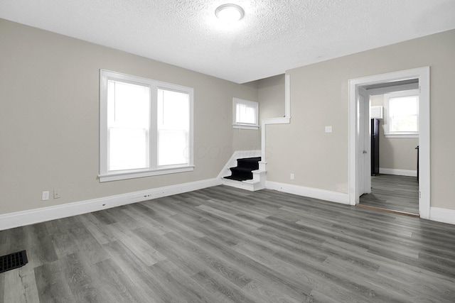 162 Columbian Ave Unit 164, Columbus, OH 43223 - unfurnished living room featuring a textured ceiling, wood finished floors, plenty of natural light, and baseboards