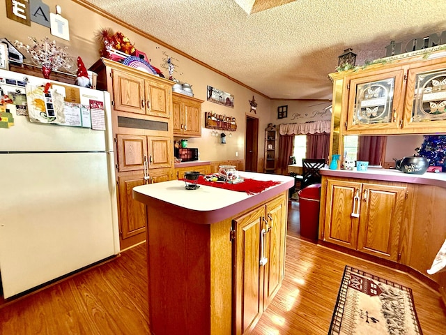 37855 Maysville Greendale Rd, Logan, OH 43138 - kitchen with freestanding refrigerator, ornamental molding, light wood-style floors, a kitchen island, and light countertops