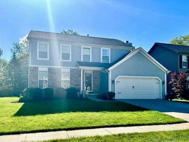 770 Oaks Edge Dr, Columbus, OH 43230 - traditional-style house featuring a garage, a front lawn, concrete driveway, and stone siding