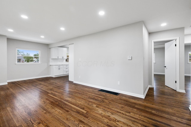 1068 E Markison Ave, Columbus, OH 43207 - unfurnished living room featuring baseboards, dark wood-type flooring, and recessed lighting
