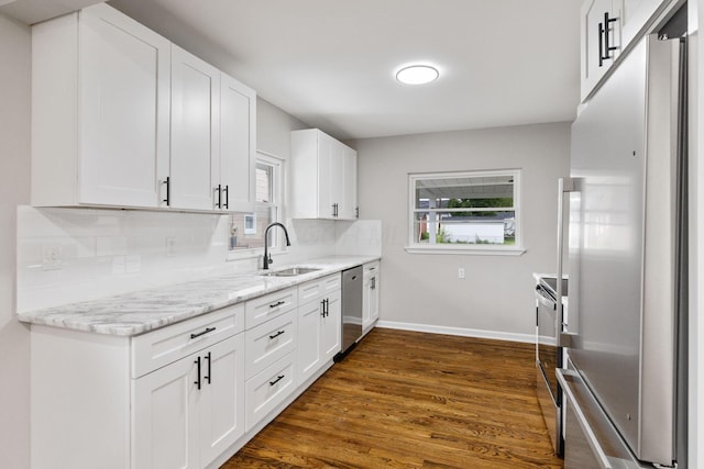 1068 E Markison Ave, Columbus, OH 43207 - kitchen featuring appliances with stainless steel finishes, a sink, backsplash, dark wood finished floors, and baseboards