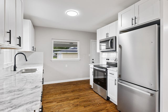1068 E Markison Ave, Columbus, OH 43207 - kitchen with stainless steel appliances, a sink, light stone counters, dark wood-style floors, and backsplash