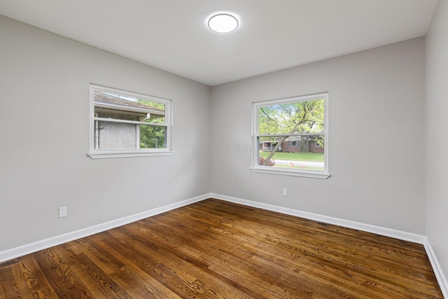 1068 E Markison Ave, Columbus, OH 43207 - unfurnished room featuring baseboards, healthy amount of natural light, and dark wood-style flooring