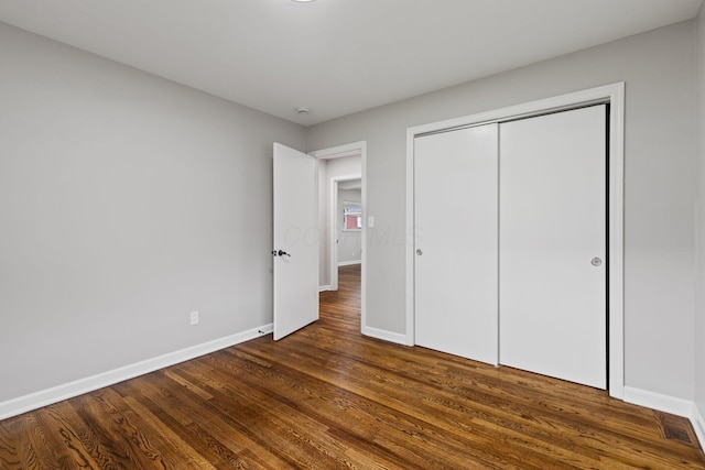 1068 E Markison Ave, Columbus, OH 43207 - unfurnished bedroom featuring baseboards, dark wood-style flooring, and a closet