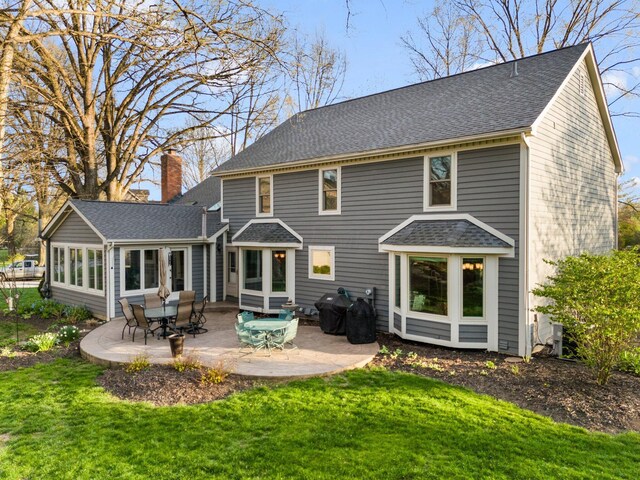 9440 Culross Ct, Dublin, OH 43017 - rear view of house with a chimney, a patio area, a lawn, and a shingled roof