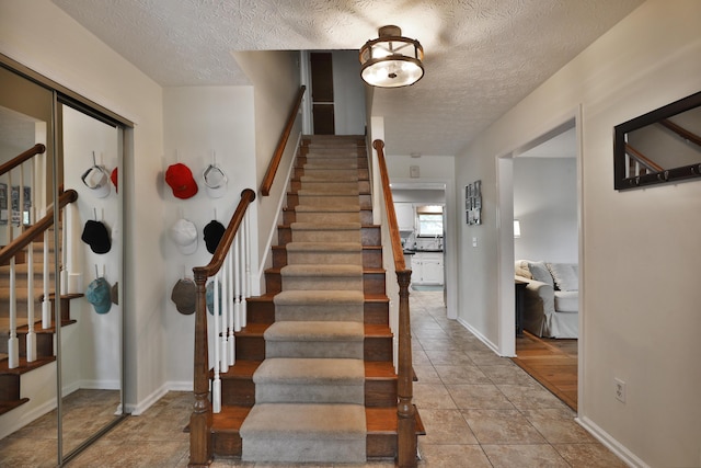 5255 Dory Ln, Columbus, OH 43235 - staircase featuring a textured ceiling and baseboards