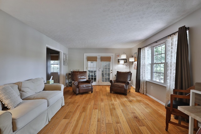 5255 Dory Ln, Columbus, OH 43235 - living room featuring light wood-type flooring, french doors, a textured ceiling, and baseboards