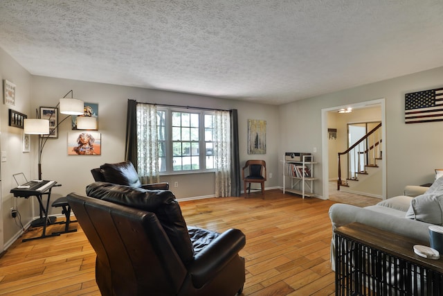 5255 Dory Ln, Columbus, OH 43235 - living room with light wood-style flooring, stairs, baseboards, and a textured ceiling