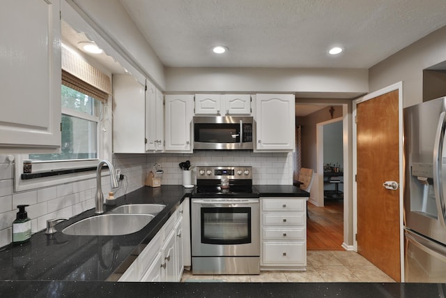 5255 Dory Ln, Columbus, OH 43235 - kitchen with appliances with stainless steel finishes, a sink, white cabinetry, dark countertops, and a textured ceiling