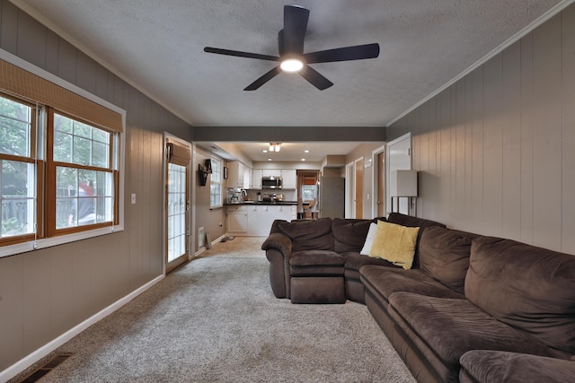 5255 Dory Ln, Columbus, OH 43235 - living room with a textured ceiling, ceiling fan, ornamental molding, light colored carpet, and baseboards