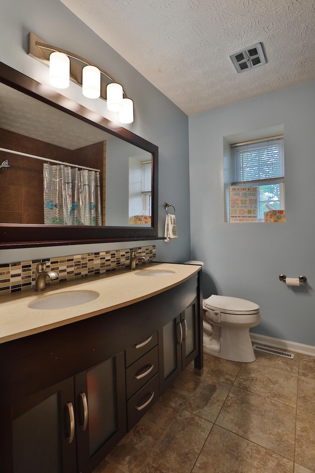 5255 Dory Ln, Columbus, OH 43235 - bathroom with double vanity, toilet, decorative backsplash, tile patterned flooring, and curtained shower
