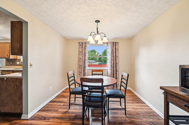 6588 Ethan Dr, Reynoldsburg, OH 43068 - dining room with a chandelier, dark wood-style flooring, baseboards, and a textured ceiling