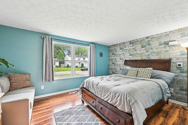 6588 Ethan Dr, Reynoldsburg, OH 43068 - bedroom with an accent wall, baseboards, wood finished floors, and a textured ceiling