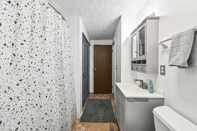 6588 Ethan Dr, Reynoldsburg, OH 43068 - bathroom featuring vanity, toilet, a textured ceiling, and a shower with curtain
