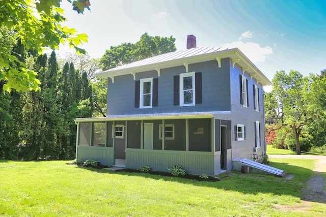12 Montgomery Rd, Fredericktown, OH 43019 - view of front of property featuring a chimney, a sunroom, a standing seam roof, a front yard, and metal roof