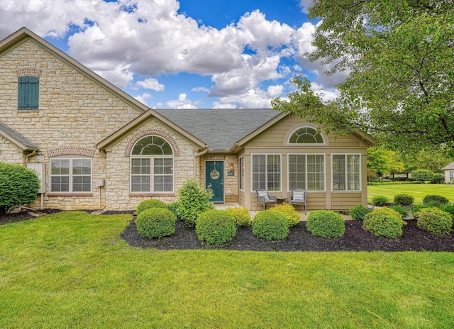 6973 Falls View Cir, Delaware, OH 43015 - view of front of home featuring stone siding, a front lawn, and roof with shingles