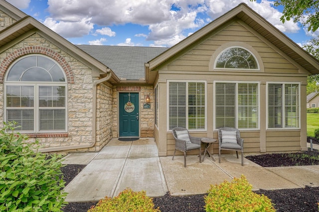 6973 Falls View Cir, Delaware, OH 43015 - entrance to property with stone siding, roof with shingles, and a patio area