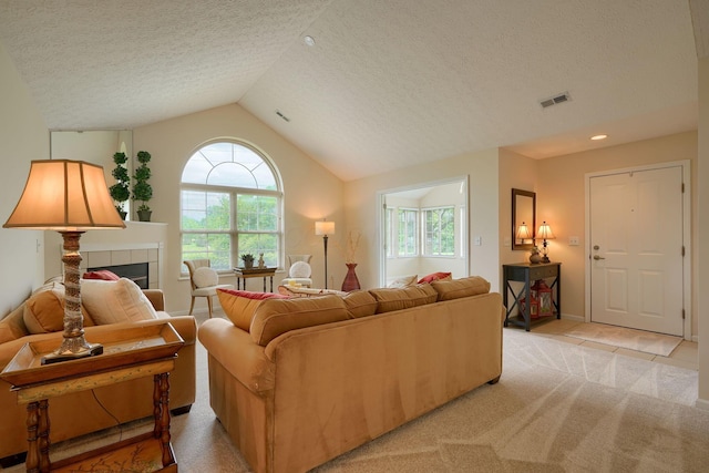 6973 Falls View Cir, Delaware, OH 43015 - living area with a tile fireplace, a textured ceiling, vaulted ceiling, light carpet, and light tile patterned floors